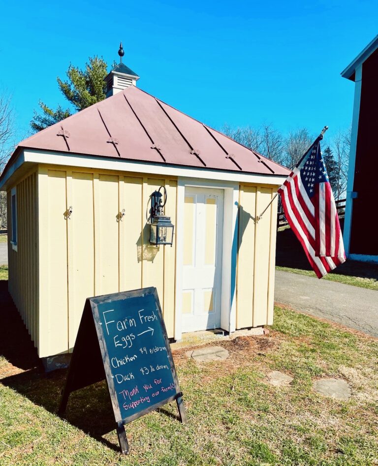 yellow shed with American flag and farm sign